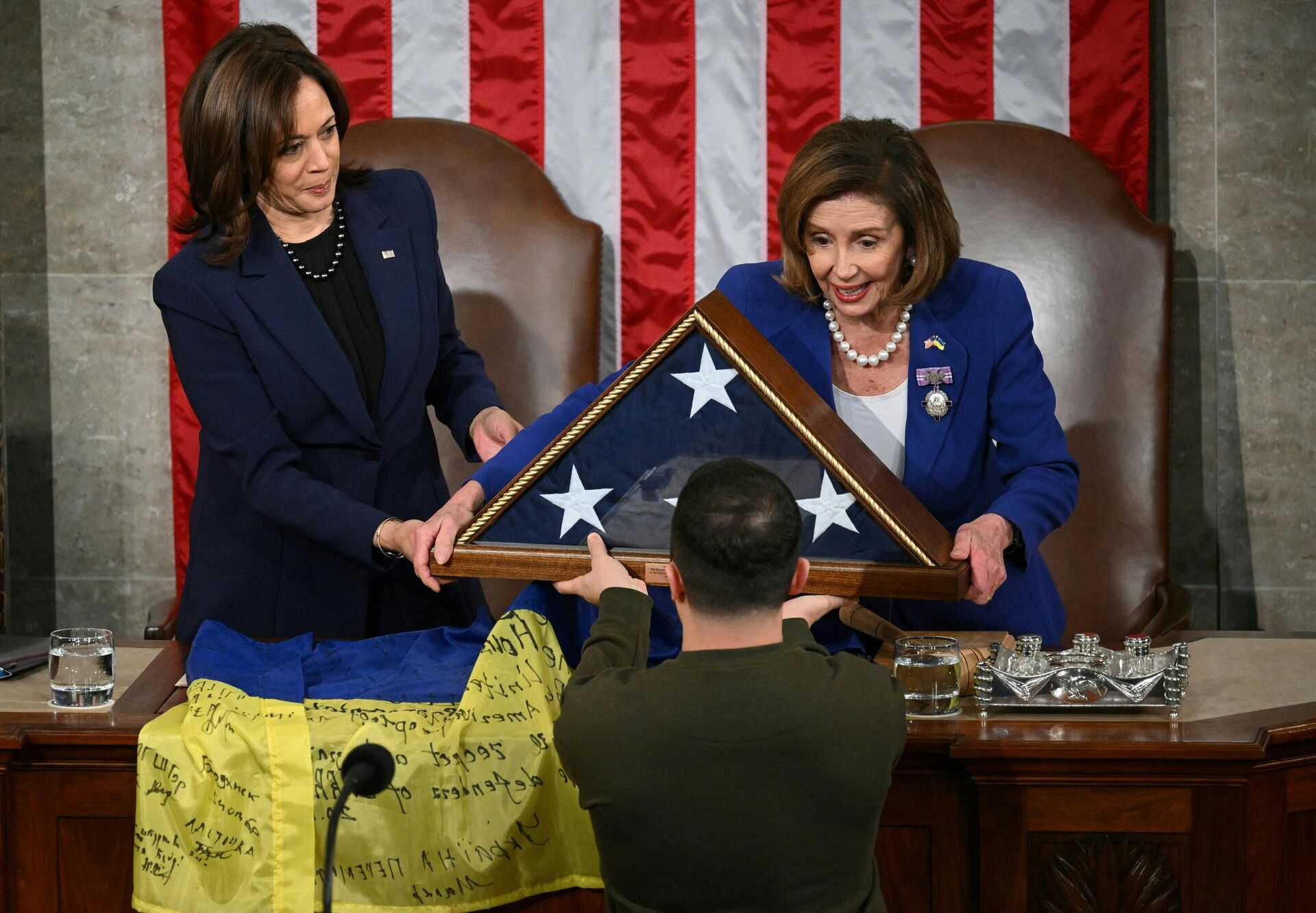 US House Speaker Nancy Pelosi (D-CA) (R) and US Vice President Kamala Harris (L) present Ukraine's President Volodymyr Zelensky an American flag after receiving a Ukrainian national flag from him following his address to the US Congress at the US Capitol in Washington, DC on December 21, 2022. - Sputnik International, 1920, 23.12.2022