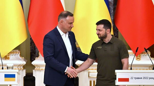 Ukrainian President Volodymyr Zelensky (R) and his Polish counterpart Andrzej Duda shake hands during a press conference following their talks in Kiev on May 22, 2022 - Sputnik International
