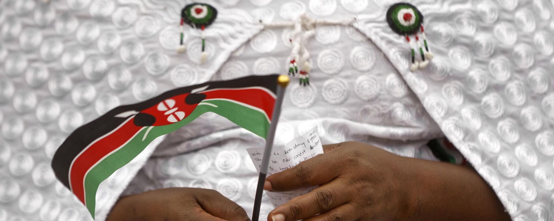 A member of the choir holds a handwritten prayer and a Kenyan flag as she participates in an evangelical pre-election prayer rally for peace, in downtown Nairobi, Kenya Sunday, July 30, 2017. - Sputnik International, 1920, 14.02.2023