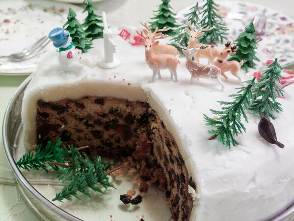 A British-style Christmas cake with marzipan and icing. In England, Christmas cake is an tradition that began as plum porridge. People ate the porridge on Christmas Eve, using it to line their stomachs after a day of fasting. Soon, dried fruit, spices and honey were added to the porridge mixture, and eventually, it turned into Christmas pudding. - Sputnik International