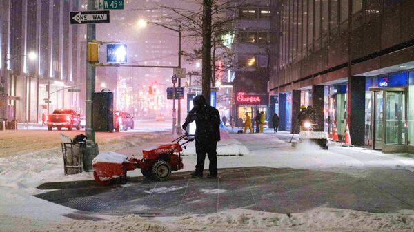 A man cleans up the snow during a snowfall in Midtown, New York, United States. - Sputnik International