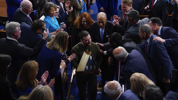 Ukrainian President Volodymyr Zelenskyy holds an American flag that was gifted to him by House Speaker Nancy Pelosi of Calif., as he leaves after addressing a joint meeting of Congress on Capitol Hill in Washington, Wednesday, Dec. 21, 2022. - Sputnik International