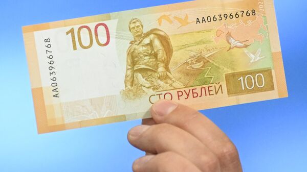 Russia's Central Bank official shows an updated version of a 100 ruble banknote. - Sputnik International