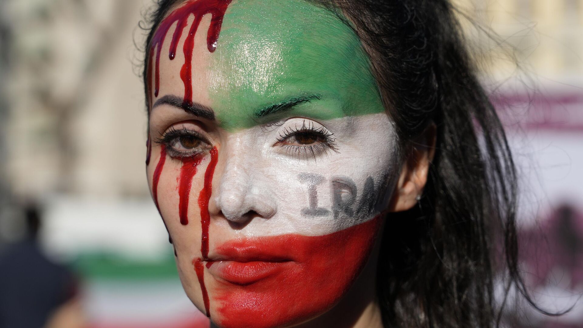 A woman is painted on a her face during a protest against the death of Mahsa Amini, a woman who died while in police custody in Iran, during a rally in central Rome, Saturday, Oct. 29, 2022. - Sputnik International, 1920, 13.03.2023