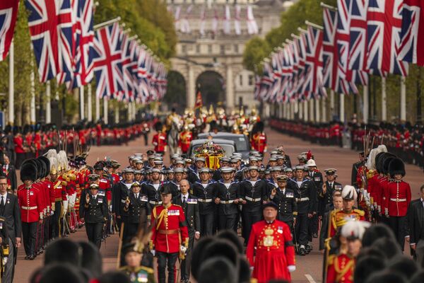 The coffin of Queen Elizabeth II is pulled past Buckingham Palace following her funeral in Westminster Abbey in central London, Monday, Sept. 19, 2022. The Queen, who died aged 96 on Sept. 8, will be buried at Windsor alongside her late husband, Prince Philip, who died last year. - Sputnik International