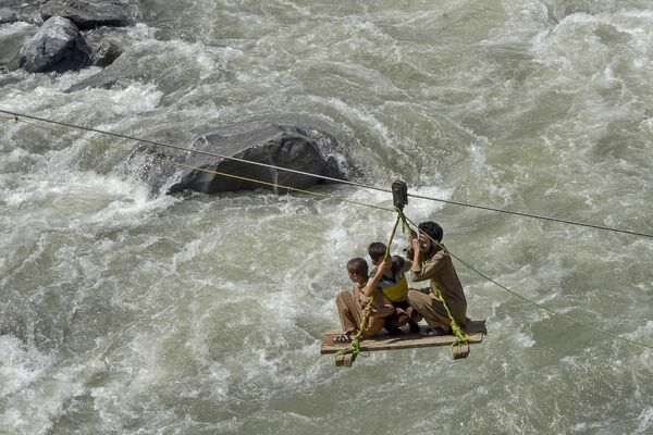 Local residents use a temporary cradle service to cross the river Swat after heavy rains in Pakistan&#x27;s Khyber Pakhtunkhwa province on August 31, 2022. Army helicopters flew sorties over cut-off areas in Pakistan&#x27;s mountainous north on August 31 and rescue parties fanned out across waterlogged plains in the south as misery mounted for millions trapped by the worst floods in the country&#x27;s history. - Sputnik International