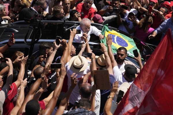 Former Brazilian President Luiz Inacio Lula da Silva, center, who was re-elected again, holds hands with a supporter after voting in a presidential run-off election in Sao Paulo, Brazil, Sunday, Oct. 30, 2022. - Sputnik International