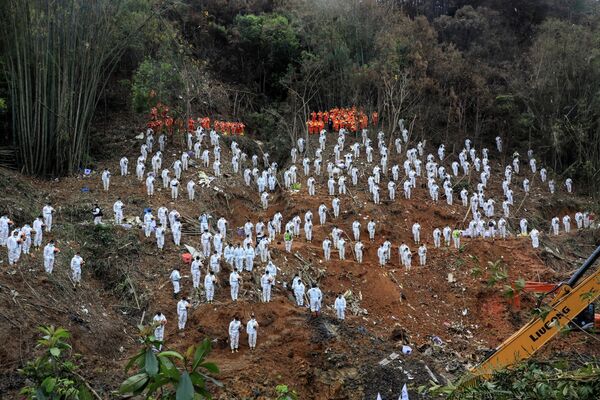 This photo taken on March 27, 2022, shows rescuers standing in a silent tribute for victims at the site of the China Eastern Airlines plane crash in Tengxian county, Wuzhou city, in China&#x27;s southern Guangxi region. The Boeing 737-800 was flying between the cities of Kunming and Guangzhou on March 21 when it nosedived into a mountainside, disintegrating on impact and killing all 132 people on board. - Sputnik International