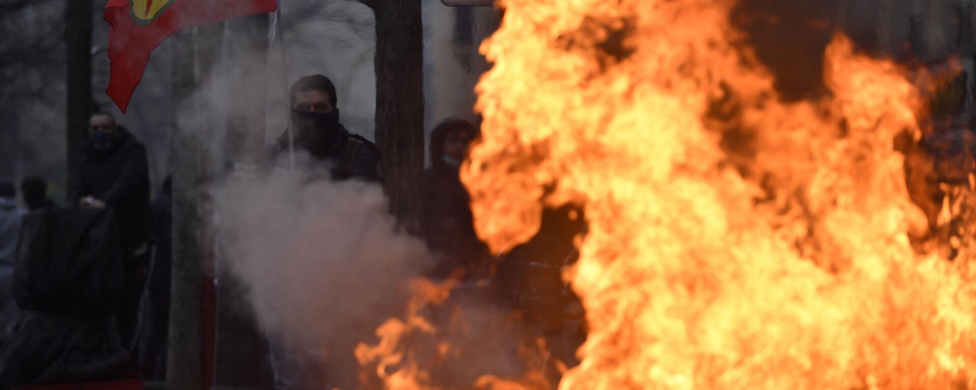 A protester holds a Kurdish workers party (PKK) flag behind a fire during clashes following a demonstration of supporters and members of the Kurdish community, a day after a gunman opened fire at a Kurdish cultural centre killing three people, at The Place de la Republique in Paris on December 24, 2022 - Sputnik International, 1920, 25.12.2022