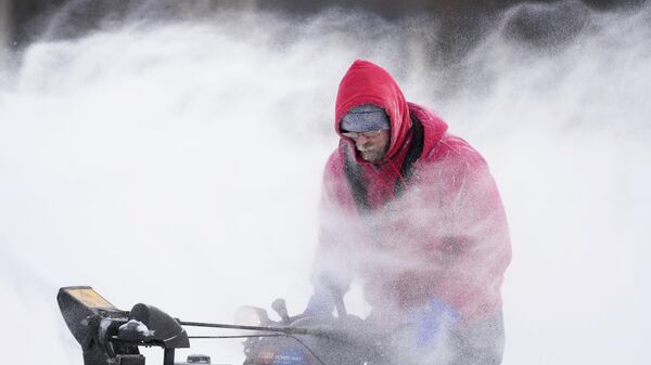 Mark Sorter clears snow from a downtown ice skating rink in Iowa. - Sputnik International