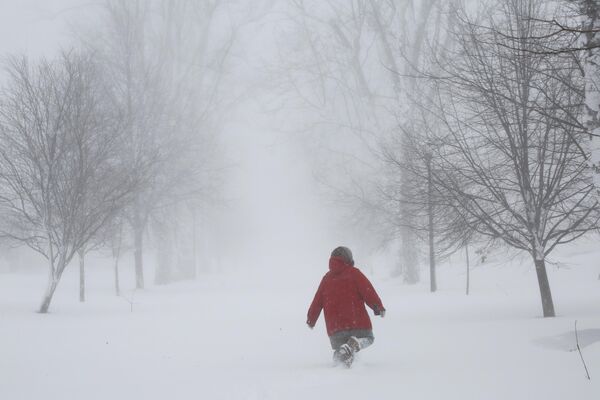 A person walks on the street as a winter storm rolls through Western New York Saturday, Dec. 24, 2022, in Amherst N.Y.  - Sputnik International