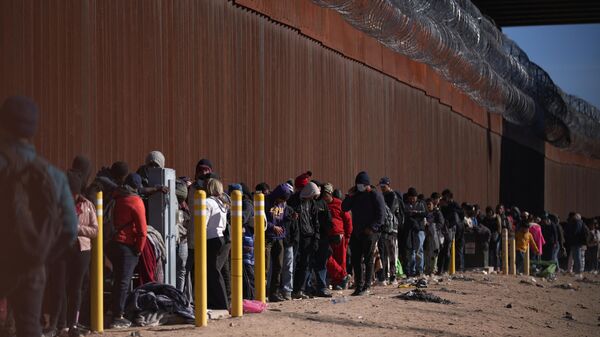 Hundreds of migrants line up to be processed by US Border Patrol under the Stanton Street Bridge after illegally entering the US, in El Paso, Texas, on December 22, 2022 - Sputnik International