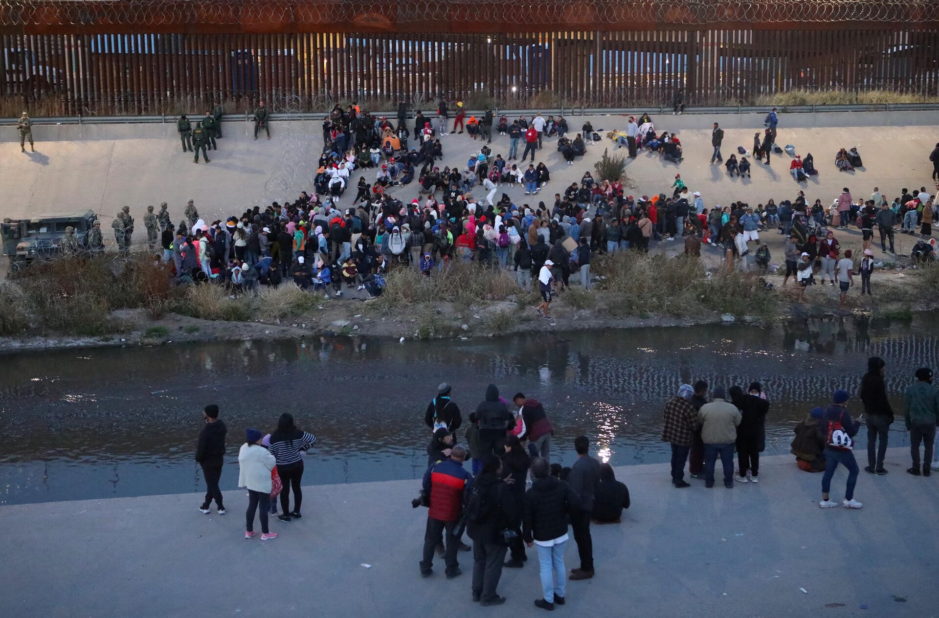 Migrants wait next to the Rio Grande as Texas National Guard soldiers prevent them from turning themselves to Border Patrol agents as seen from Ciudad Juarez, Chihuahua state, Mexico, December 20, 2022 - Sputnik International, 1920, 26.12.2022