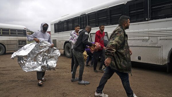 Migrants board a bus that will take them to a processing facility to begin their process of seeking asylum in Eagle Pass, Texas on December 19, 2022 - Sputnik International