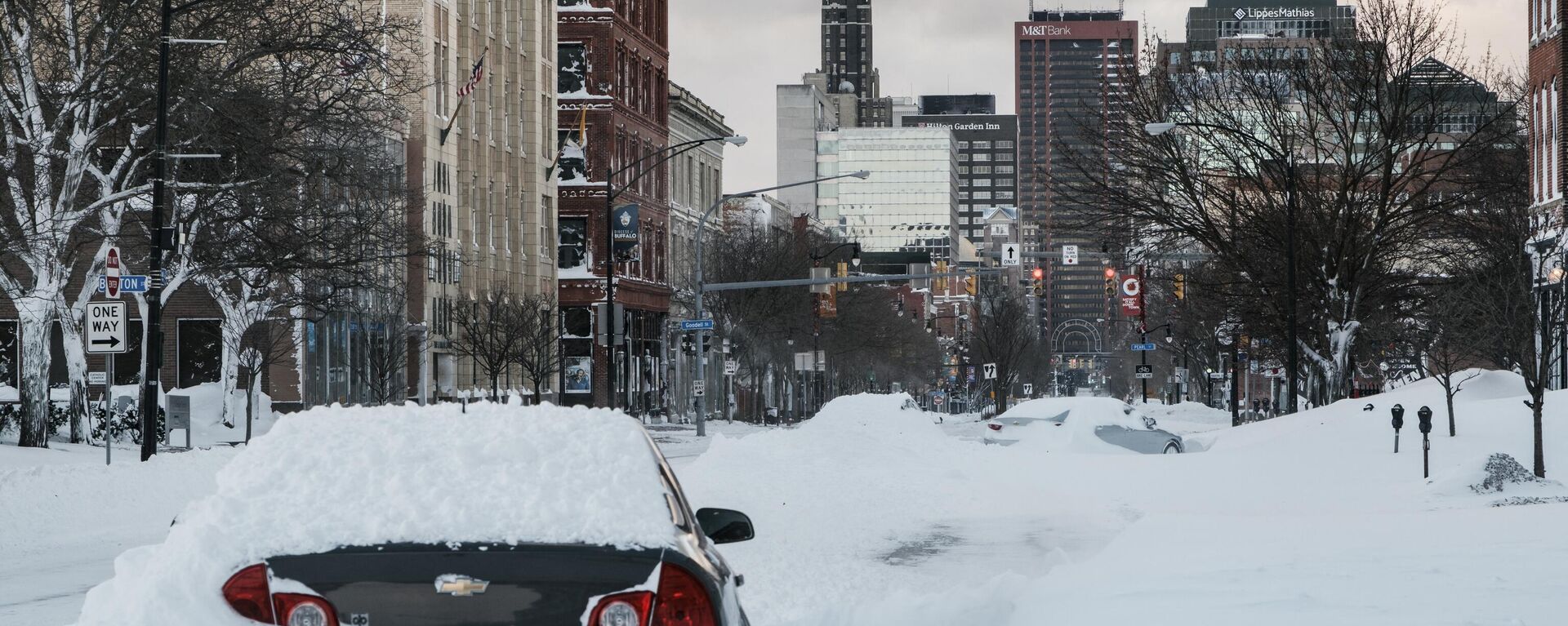 An abandoned vehicle is left under heavy snow along a street in Buffalo, New York, on December 25, 2022. - Sputnik International, 1920, 27.12.2022