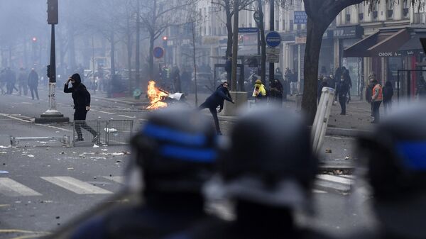 A protester throws projectiles towards riot police as clashes erupt following a demonstration of members of the Kurdish community, a day after a gunman opened fire at a Kurdish cultural centre killing three people, at The Place de la Republique in Paris on December 24, 2022. - Sputnik International