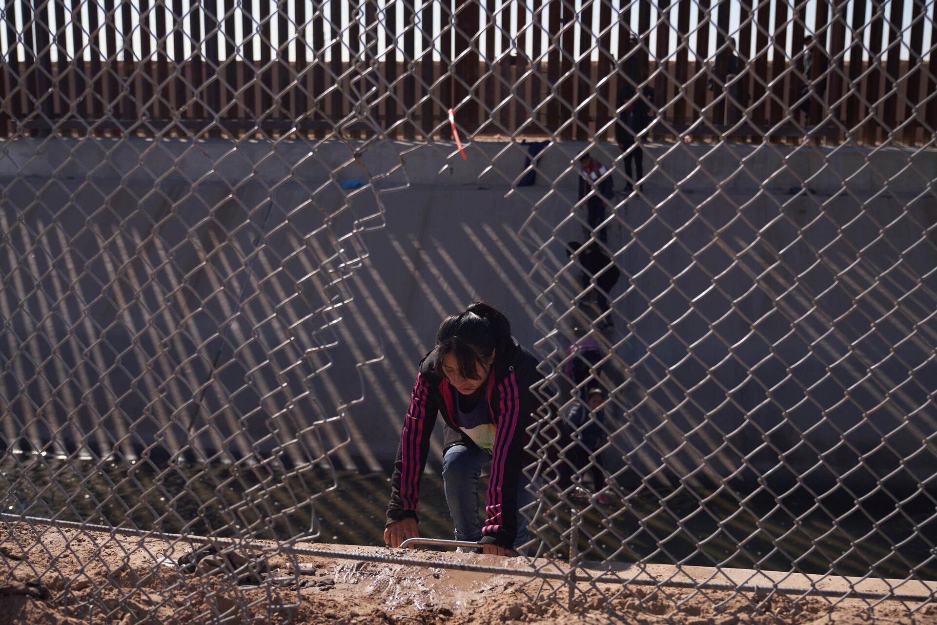 Migrants illegally cross into the United States from Mexico via a hole cut in the border fence in El Paso, Texas, US on December 21, 2022.  - Sputnik International, 1920, 28.12.2022