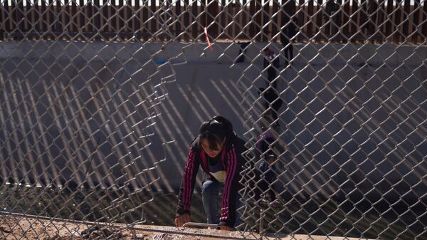Migrants illegally cross into the United States from Mexico via a hole cut in the border fence in El Paso, Texas, US on December 21, 2022.  - Sputnik International