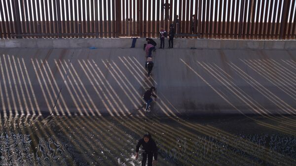 Migrants illegally cross into the United States from Mexico via a hole cut in the border fence in El Paso, Texas, US on December 21, 2022.  - Sputnik International