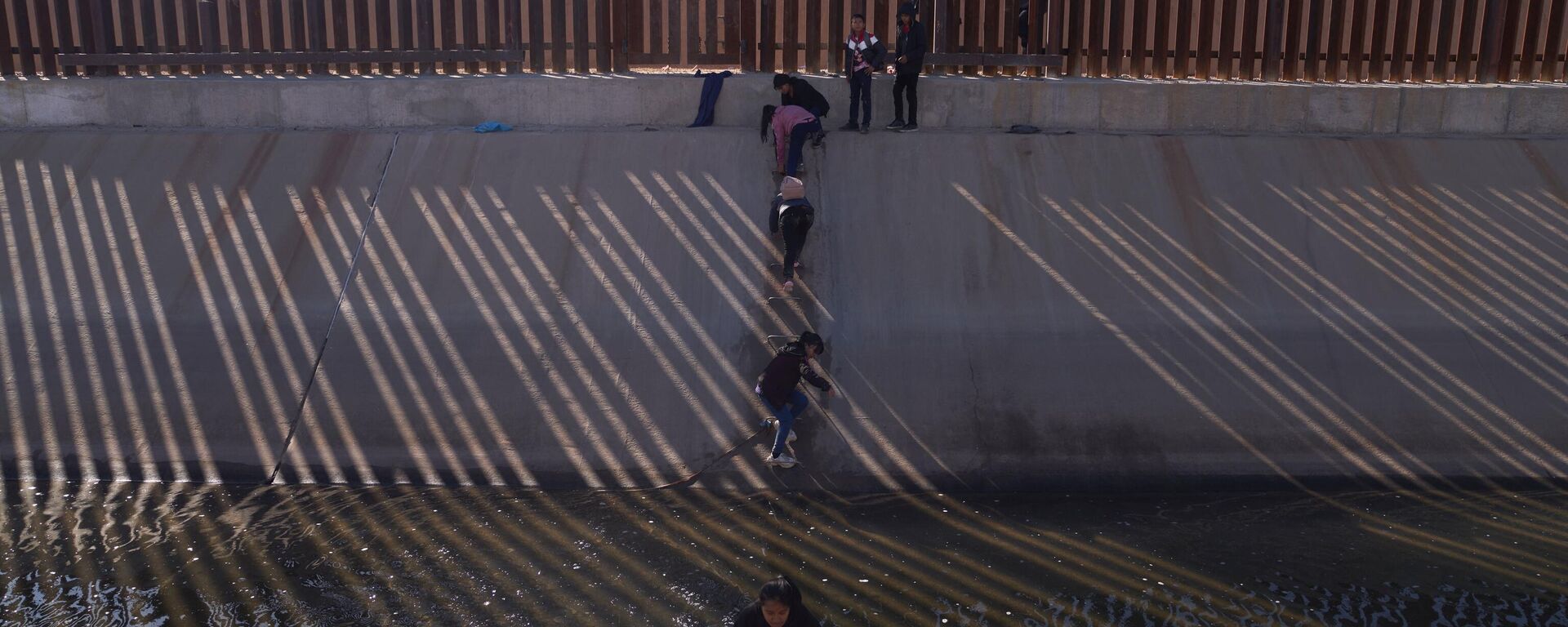 Migrants illegally cross into the United States from Mexico via a hole cut in the border fence in El Paso, Texas, US on December 21, 2022.  - Sputnik International, 1920, 28.12.2022