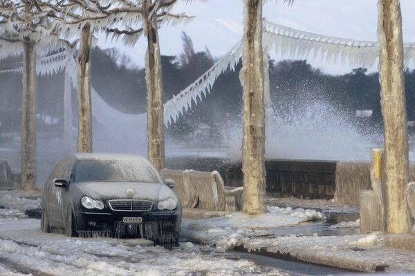 A car, telephone lines and the shores of Lake Geneva near Versoix, Switzerland, are covered with ice in this picture taken on Wednesday 26 January 2005. Strong gusts of wind spraying water from the lake combined with temperatures below freezing to ice up the region of Lake Geneva. - Sputnik International