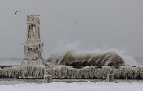 The large waves pound the shore as ice covers the pier on Monday 13 December 2010, in Chicago Illinois. High wind and freezing temperatures exacerbated a situation after a winter storm pummeled the state with snow and wind over the weekend. - Sputnik International