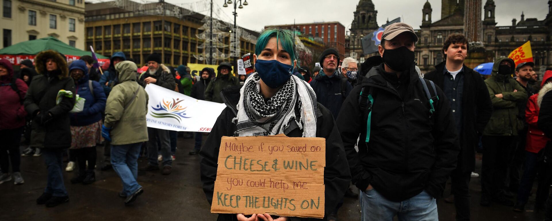 Demonstrators hold up placards as they take part in a march organised by The People's Assembly to demand action to tackle the cost of living crisis in Glasgow, Scotland on February 12, 2022. - Sputnik International, 1920, 12.01.2023