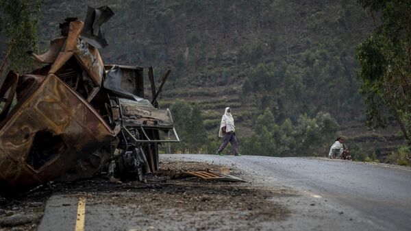 A man crosses near a destroyed truck on a road leading to the town of Abi Adi, in the Tigray region of northern Ethiopia on May 11, 2021. - Sputnik International