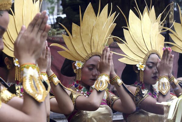 Women dancers pray before they perform during the culture parade to bid farewell to 2022 and welcome 2023 in Bali, Indonesia, on Saturday, Dec. 31, 2022. - Sputnik International