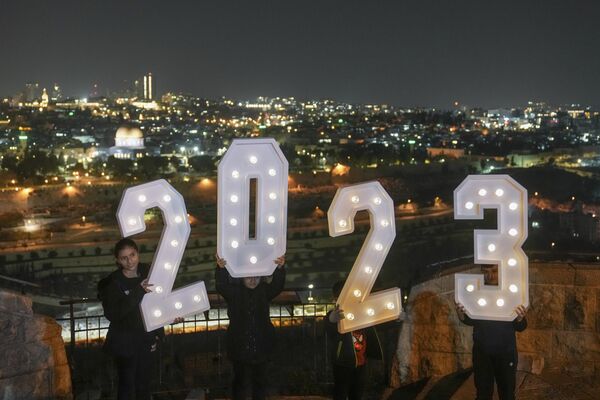 People pose for pictures with a 2023 installation as they celebrate the New Year&#x27;s Eve at Mount of Olives overlooking Jerusalem&#x27;s Old City, Saturday, Dec. 31, 2022. - Sputnik International