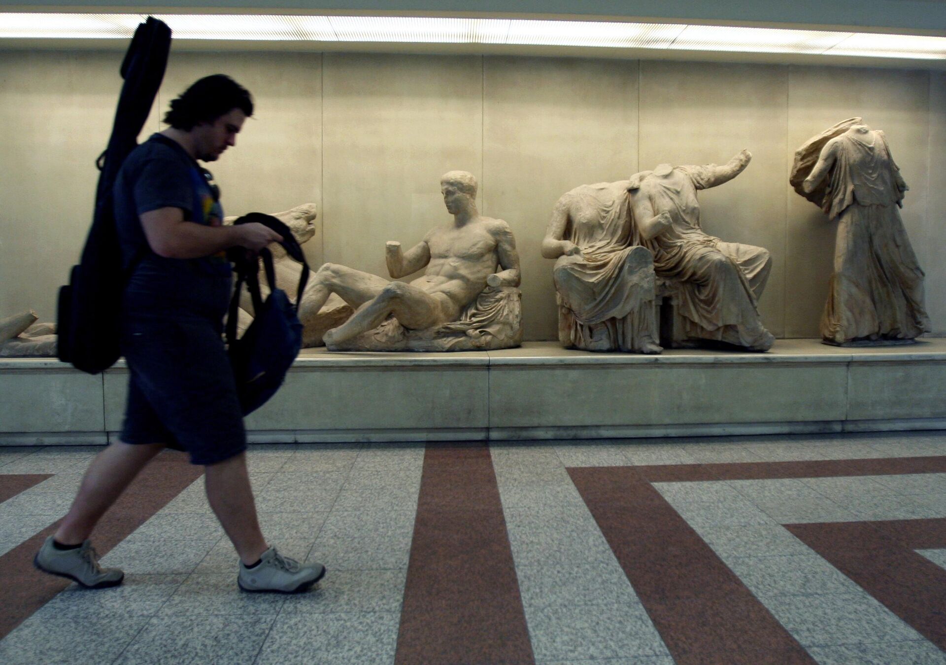 A passenger walks past copies of some of the Parthenon Sculptures displayed in the British Museum, at the Acropolis Metro station in Athens, on Thursday, June 11, 2009.  - Sputnik International, 1920, 05.01.2023