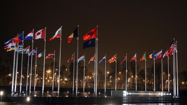 The picture shows the flags of the participating countries raised in front of the headquarters of the North Atlantic Treaty Organization (NATO - Sputnik International