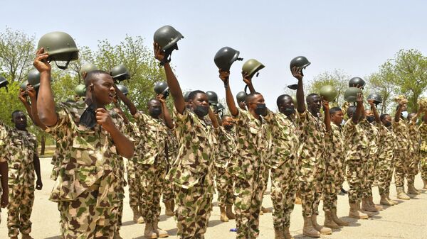 Soldiers gesture while standing on guard during Nigerian President Muhammadu Buhari's visit to the Maimalari Barracks in Maiduguri on June 17, 2021. - Sputnik International