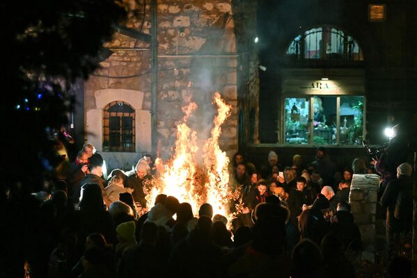 Local residents attend the annual bonfire of dried oak branches to mark the Orthodox Christmas Eve at the Church of the Holy Archangels Michael and Gabriel in Sarajevo on January 6. (Photo by ELVIS BARUKCIC / AFP) - Sputnik International
