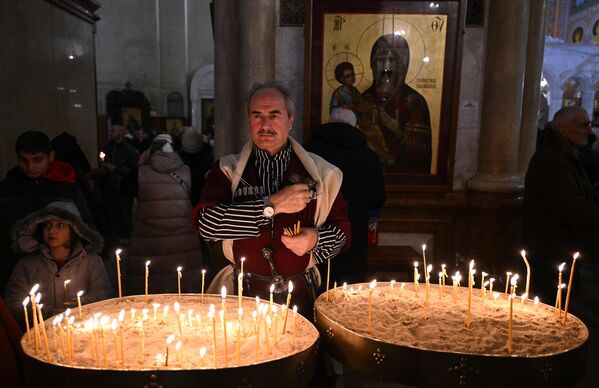 A believer attends the Orthodox Christmas service at the Cathedral of Sameba in Tbilisi, Georgia, on January 6. (Photo by Vano SHLAMOV / AFP) - Sputnik International