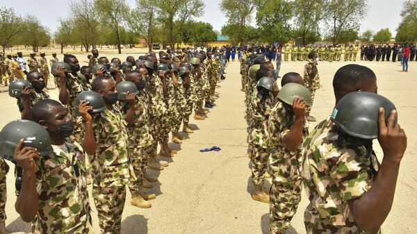 Soldiers gesture while standing on guard during Nigerian President Muhammadu Buhari's visit to the Maimalari Barracks in Maiduguri on June 17, 2021. - Sputnik International