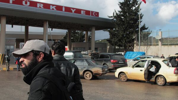 People and cars wait at the Bab al-Hawa customs gate at theSyria-Turkey border in Idlib province, north Syria - Sputnik International