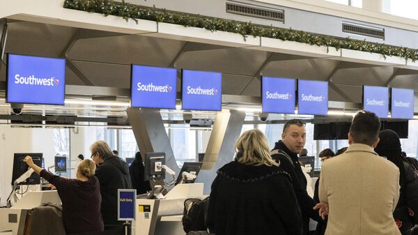Passengers wait in line to check in for their flights at Southwest Airlines service desk at LaGuardia Airport, Tuesday, Dec. 27, 2022, in New York.  - Sputnik International