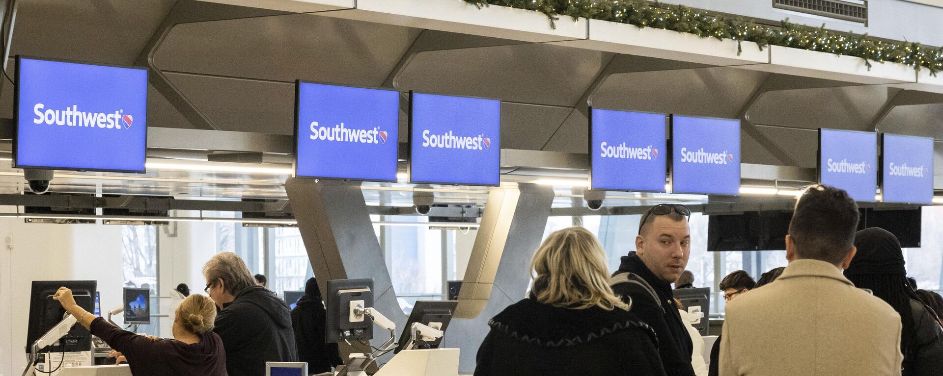 Passengers wait in line to check in for their flights at Southwest Airlines service desk at LaGuardia Airport, Tuesday, Dec. 27, 2022, in New York.  - Sputnik International, 1920, 07.03.2023