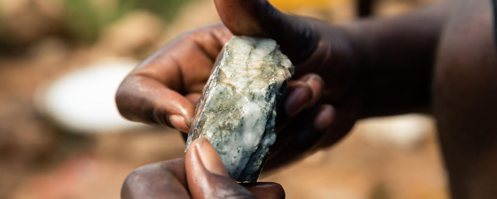 A young miner looks at an ore sample searching for gold during a mine search and rescue operation at Cricket Mine in Kadoma, Mashonaland West Province where more than 23 artisinal miners are trapped underground and feared dead on February 15, 2019.  - Sputnik International, 1920, 11.01.2023
