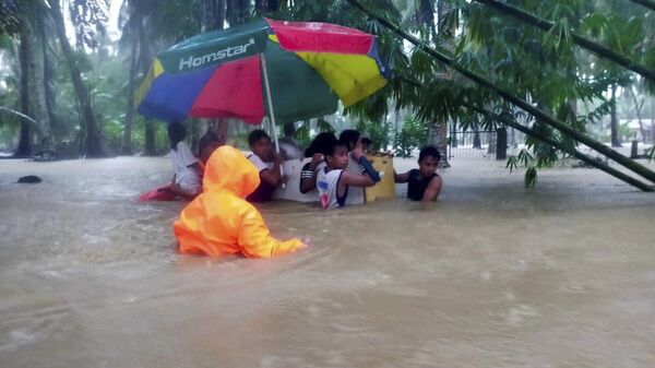 In this photo provided by the Philippine Coast Guard, rescuers use an old refrigerator as a float as they evacuate residents from flood waters caused by Tropical Storm Nalgae in Hilongos, Leyte province, Philippines on Friday Oct. 28, 2022. - Sputnik International