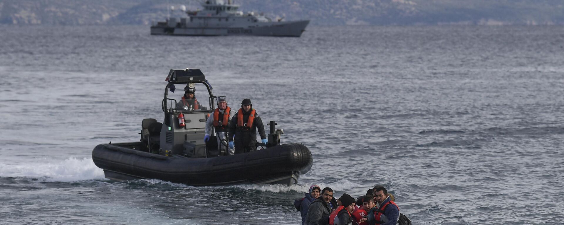 A dinghy with Afghan refugees approaches the Greek island of Lesbos on February 28, 2020 next to UK Border Force patrol boat HMC Valiant, patroling in Agean sea under European Union border force Frontex. - Sputnik International, 1920, 13.01.2023