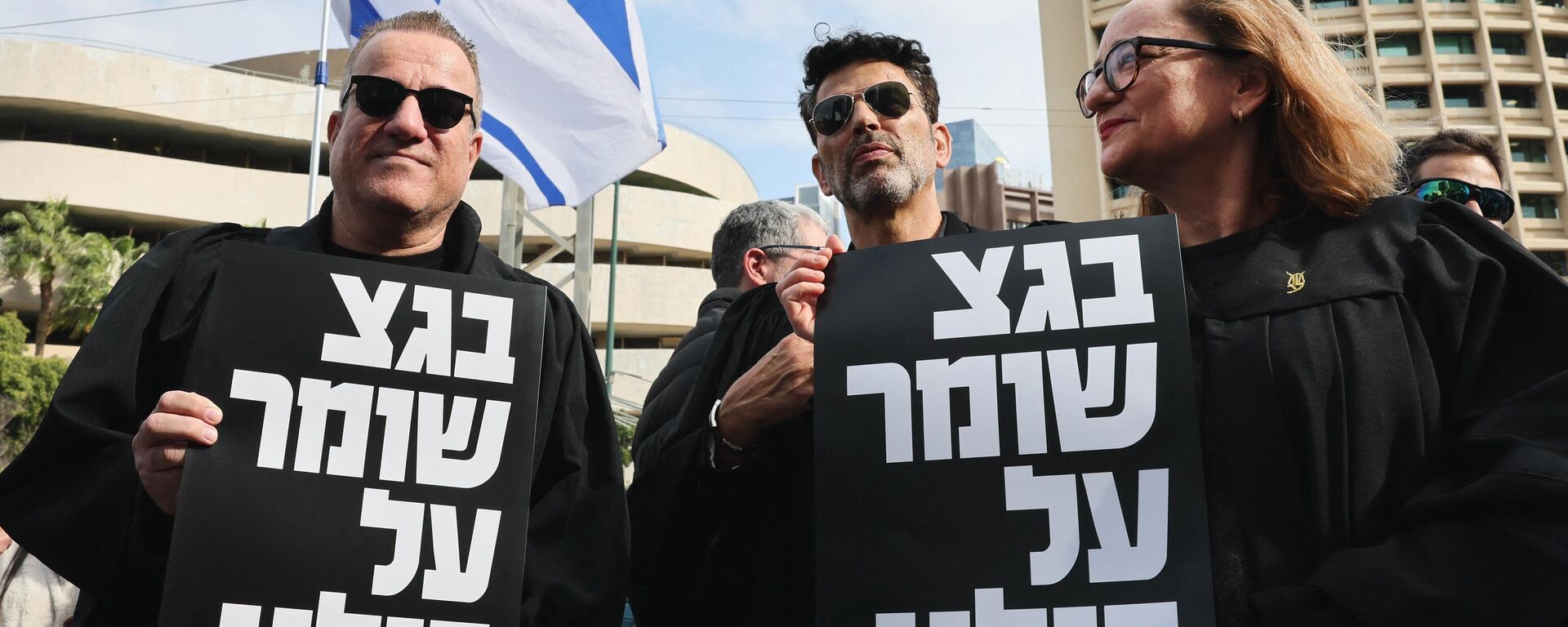 Lawyers hold signs with writing in Hebrew reading the supreme court protects us all during a demonstration by lawyers against the Israeli government's controversial plans to overhaul the judicial system, outside the Tel Aviv District Court of Justice on January 12, 2023.  - Sputnik International, 1920, 16.01.2023