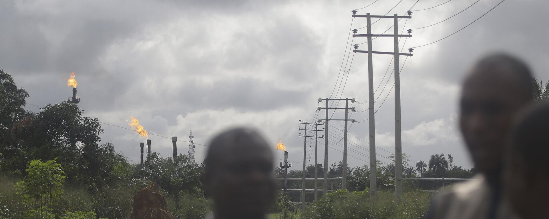 Local people stand and talk with gas flares belonging to the Agip Oil company in the background in Idu, Niger Delta area of Nigeria, Friday, Oct. 8, 2021 - Sputnik International, 1920, 08.03.2023