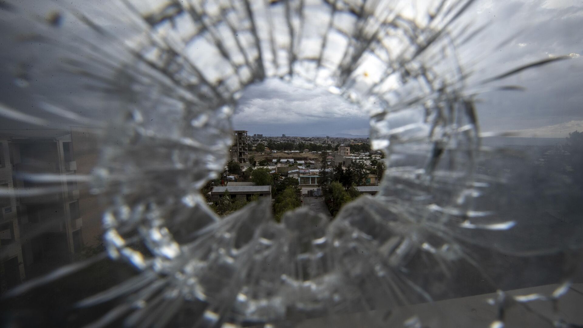 The city of Mekele is seen through a bullet hole in a stairway window of the Ayder Referral Hospital in the Tigray region of northern Ethiopia on May 6, 2021 - Sputnik International, 1920, 15.01.2023