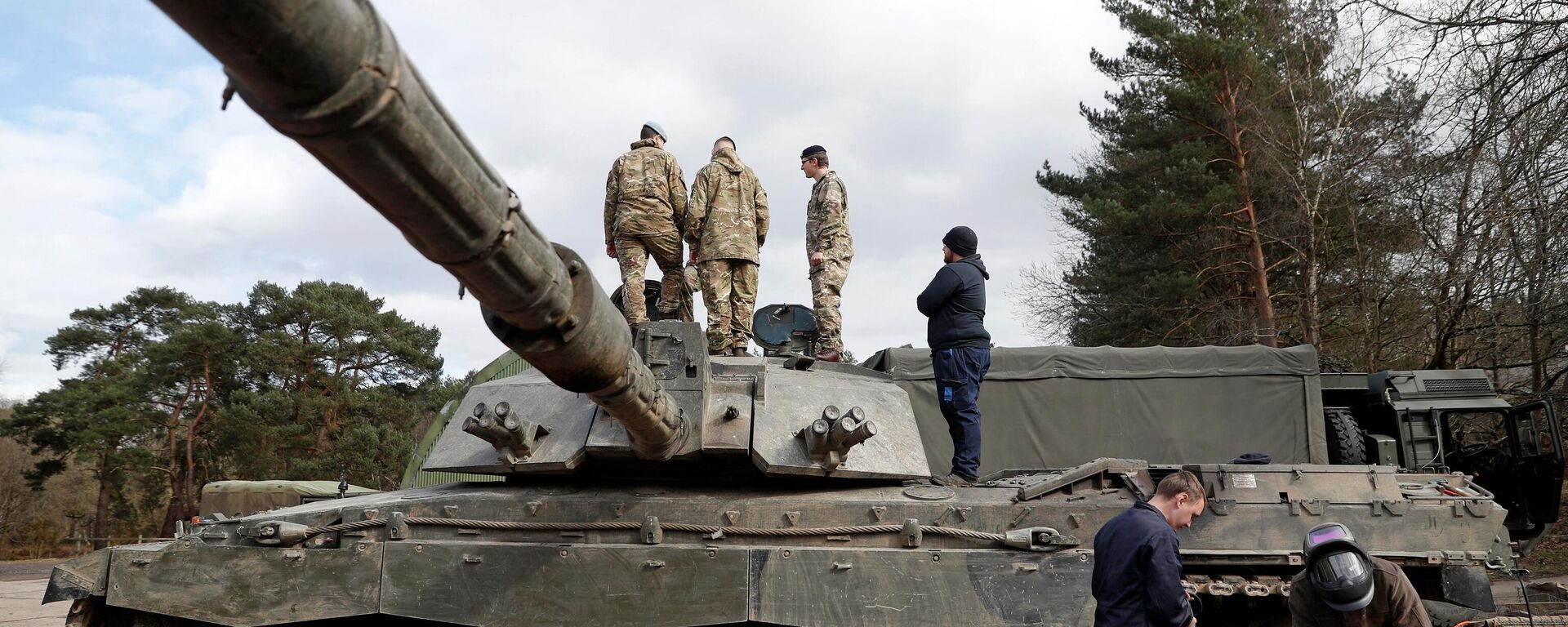 Soldiers work on a Challenger 2 main battle tank during during the Royal Electrical & Mechanical Engineers’ training exercise called Iron Challenge at the Longmoor training area, near Bordon, Hampshire, on March 14, 2022 - Sputnik International, 1920, 18.01.2023