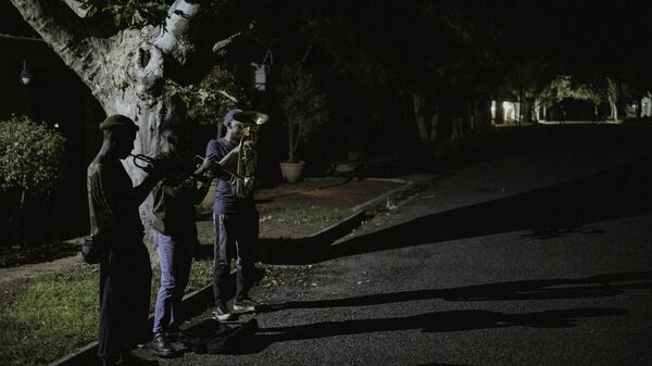 Members of The Middle of the Road Band, trumpet player Smiso (L), 24, trumpet player Franqo (C), 28, and euphonium player Pro (R), 30, play Christmas carols in Johannesburg, in the middle of yet another crippling black out, known locally as load shedding, on December 20, 2022.  - Sputnik International
