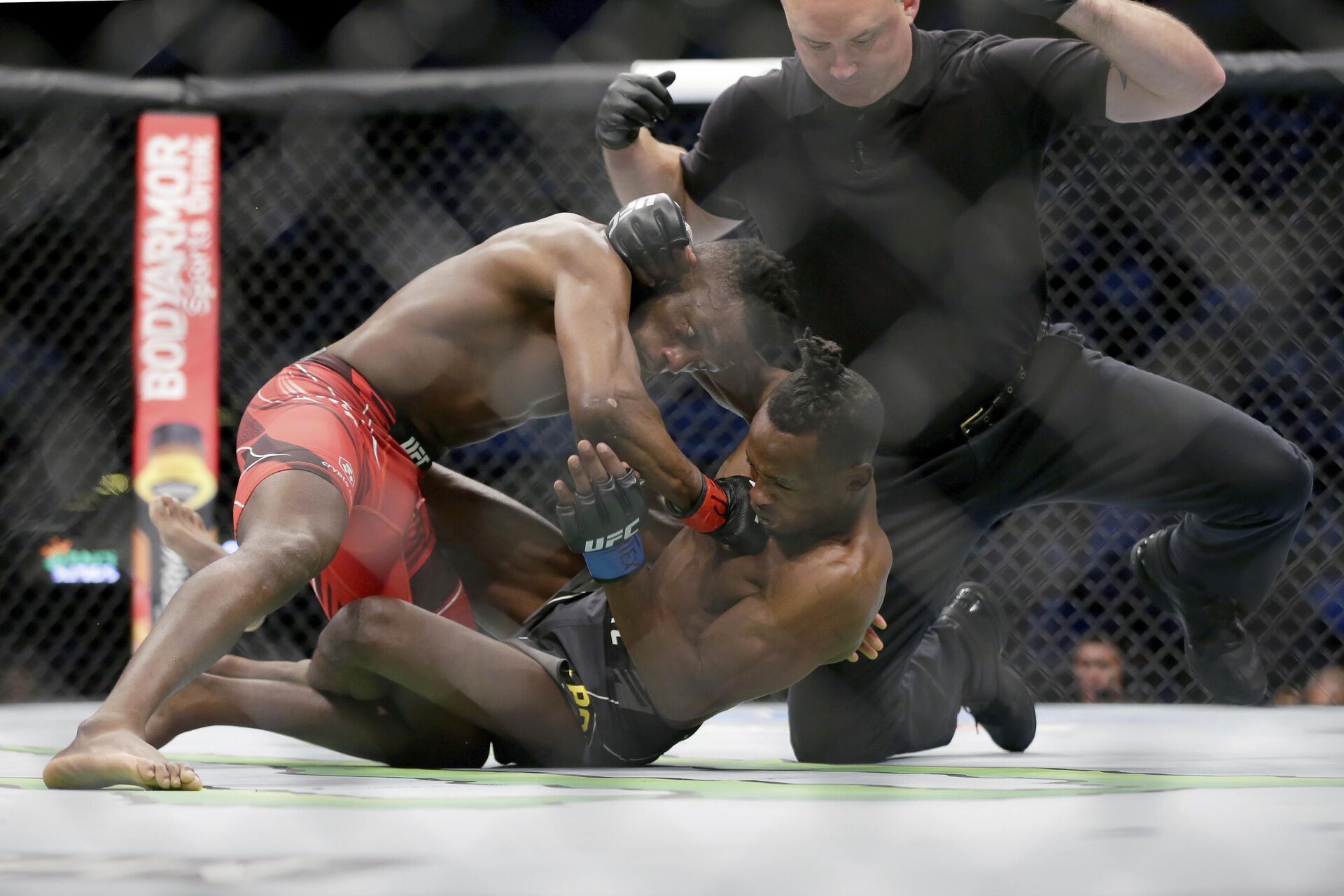 Manel Kape, left, punches Ode Osbourne, middle, after taking him down for a technical knockout in front of referee Jeff Rexroad, right, during their flyweight mixed martial arts bout at UFC 265 on Saturday, Aug. 7, 2021, in Houston.  - Sputnik International, 1920, 18.01.2023