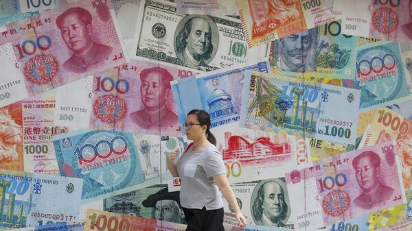 A woman walks by a money exchange shop decorated with banknotes of Chinese yuan and US dollars at Central, a business district in Hong Kong, Tuesday, Aug. 6, 2019. - Sputnik International