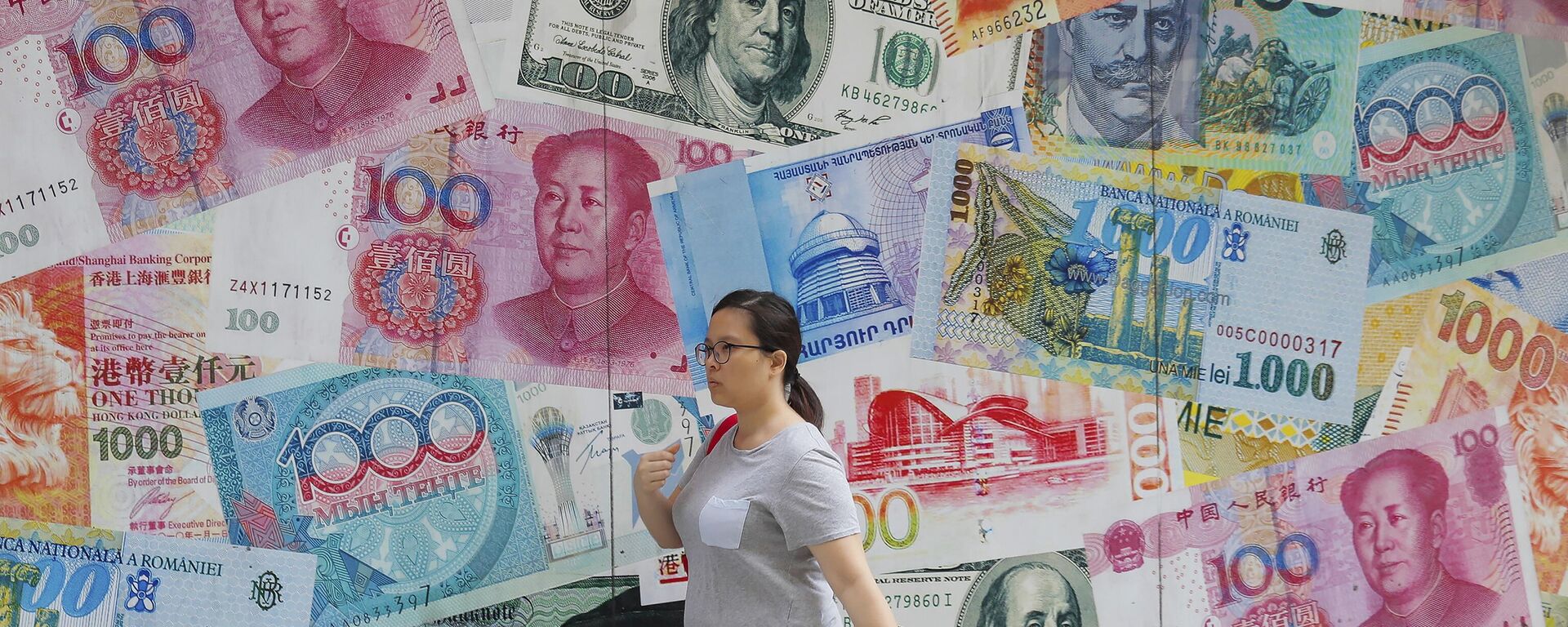A woman walks by a money exchange shop decorated with banknotes of Chinese yuan and US dollars at Central, a business district in Hong Kong, Tuesday, Aug. 6, 2019. - Sputnik International, 1920, 11.07.2023